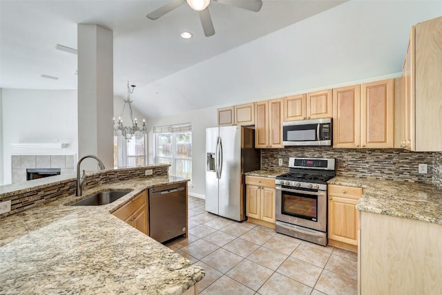 kitchen with light tile patterned floors, decorative backsplash, appliances with stainless steel finishes, light brown cabinets, and a sink