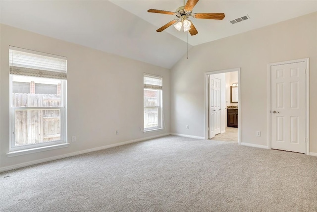 empty room with visible vents, a ceiling fan, light carpet, vaulted ceiling, and baseboards