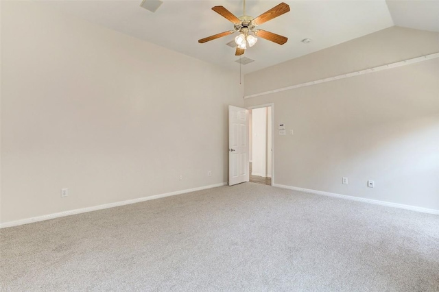 spare room featuring light carpet, vaulted ceiling, baseboards, and ceiling fan