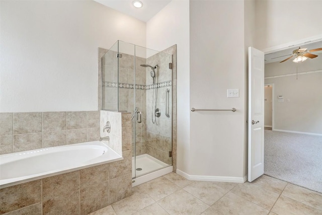 bathroom featuring a garden tub, tile patterned flooring, a ceiling fan, baseboards, and a shower stall