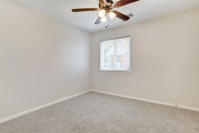 carpeted empty room featuring baseboards, visible vents, and a ceiling fan