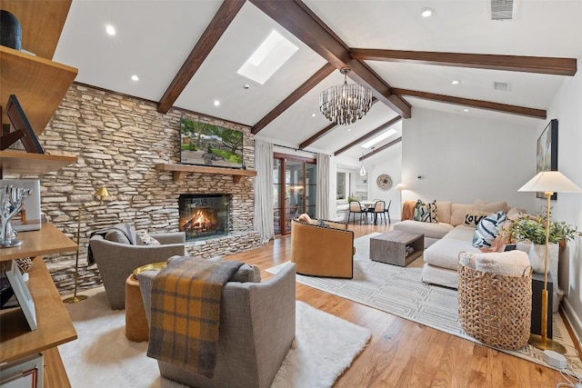 living room with beam ceiling, a fireplace, a notable chandelier, visible vents, and wood finished floors