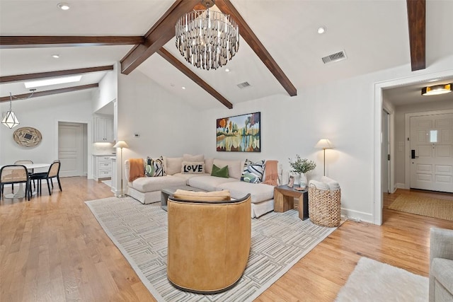 living area with visible vents, beamed ceiling, and light wood finished floors