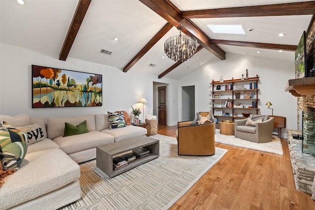 living room with a chandelier, a fireplace, wood finished floors, and visible vents