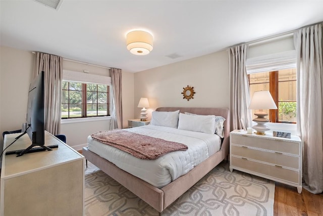 bedroom with light wood finished floors and visible vents