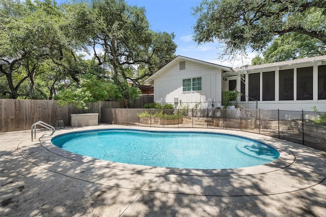 view of pool with a sunroom, a patio, fence, and a fenced in pool