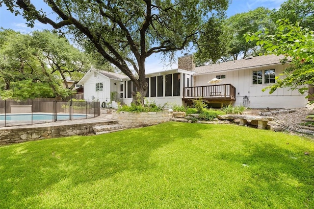 back of house with a fenced in pool, a sunroom, a chimney, fence, and a yard