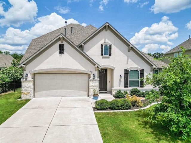 french country inspired facade featuring a garage, stone siding, driveway, roof with shingles, and stucco siding