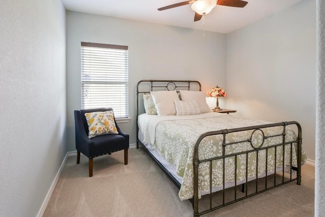 carpeted bedroom with baseboards and a ceiling fan