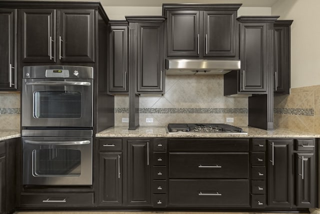 224 Tavish Trl, Austin, TX 78738 - kitchen featuring appliances with stainless steel finishes, backsplash, under cabinet range hood, and light stone counters
