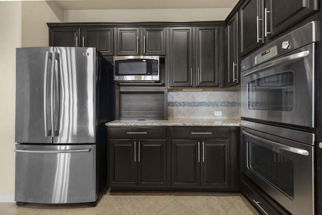 224 Tavish Trl, Austin, TX 78738 - kitchen with appliances with stainless steel finishes, light stone counters, light tile patterned floors, and decorative backsplash