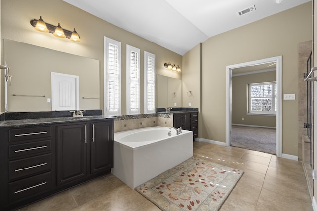 224 Tavish Trl, Austin, TX 78738 - bathroom featuring tile patterned flooring, vanity, a garden tub, a shower stall, and vaulted ceiling