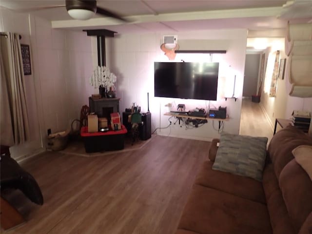 living room featuring a wood stove, wood finished floors, and visible vents