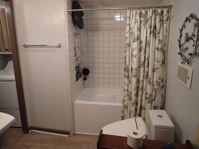 full bathroom featuring washer / dryer, shower / bath combo with shower curtain, and wood finished floors