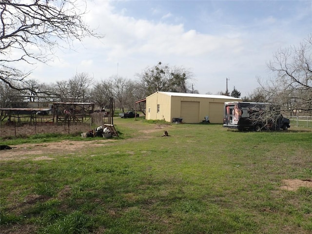 view of yard featuring an outbuilding, a pole building, and a detached garage