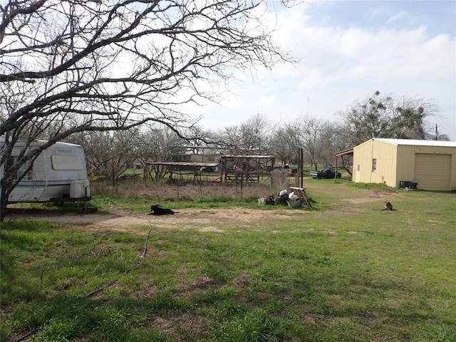 view of yard with a garage and an outbuilding