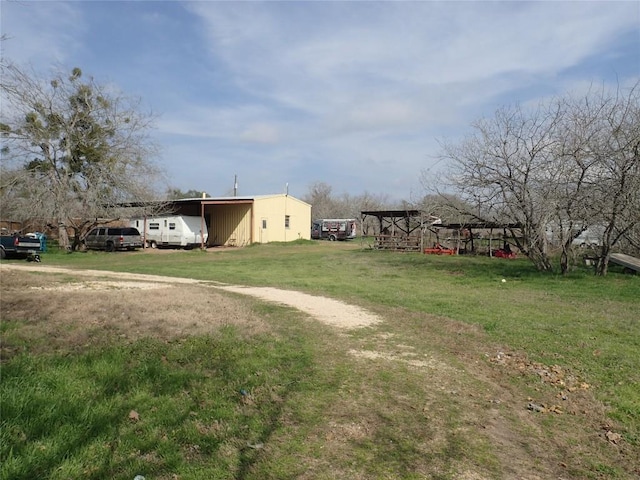 view of yard with an outbuilding, a carport, and a pole building