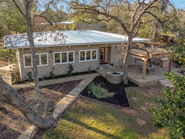 view of front facade featuring metal roof and a patio