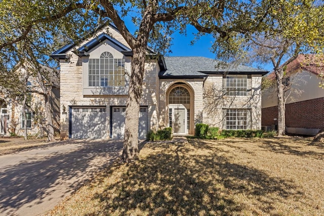 view of front of property with a garage, driveway, roof with shingles, and stone siding