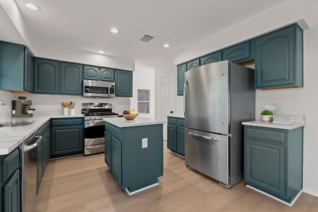 kitchen with visible vents, stainless steel appliances, light countertops, light wood-type flooring, and a sink