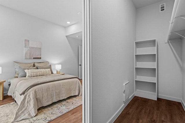 bedroom with visible vents, baseboards, and wood finished floors