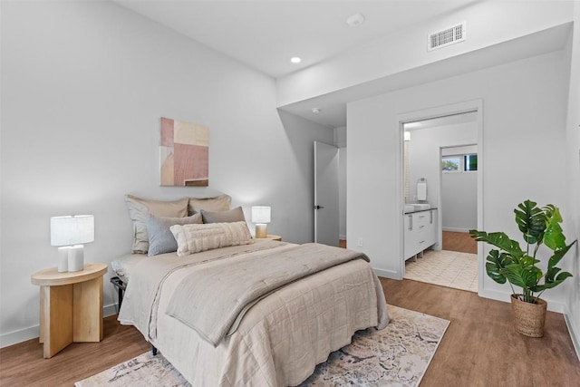 bedroom featuring connected bathroom, recessed lighting, wood finished floors, visible vents, and baseboards