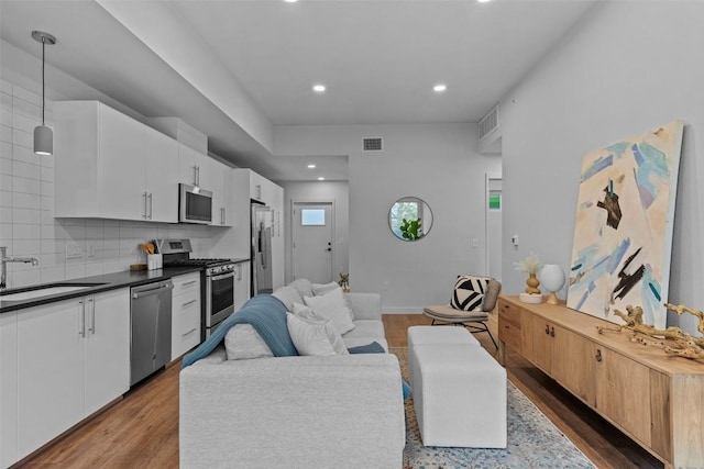 living area featuring recessed lighting, visible vents, dark wood finished floors, and baseboards