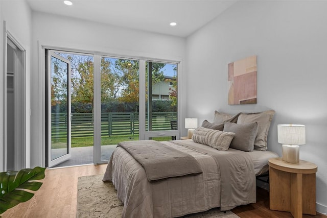 bedroom with access to exterior, wood finished floors, and recessed lighting