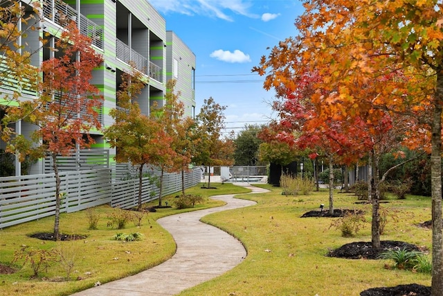 view of property's community with fence and a yard