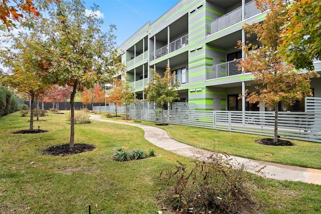 view of property's community featuring a yard and fence