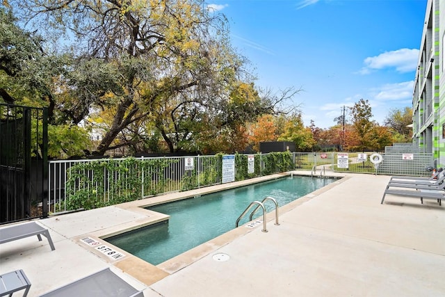 community pool with a patio and fence