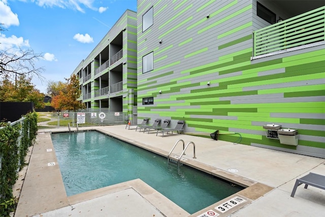 pool with fence and a patio