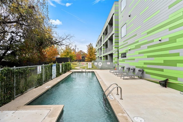 pool with a patio and fence