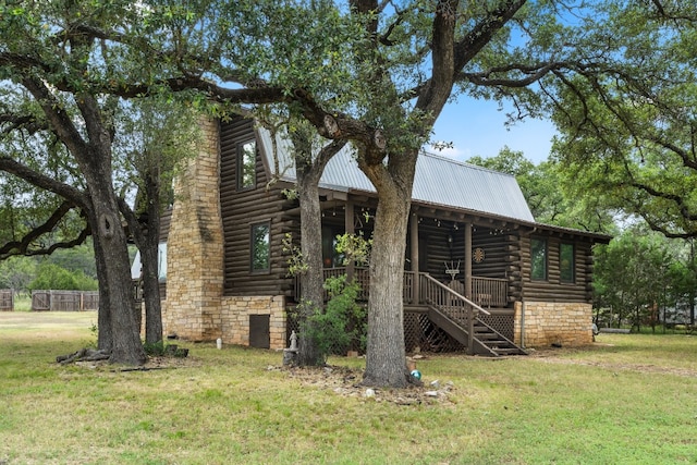 view of side of property with metal roof, a lawn, and log exterior