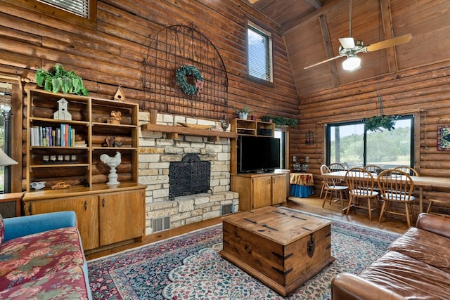 living area featuring rustic walls, wood ceiling, wood finished floors, a stone fireplace, and high vaulted ceiling