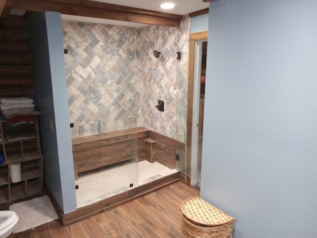 full bath featuring wood finished floors, toilet, and a shower stall