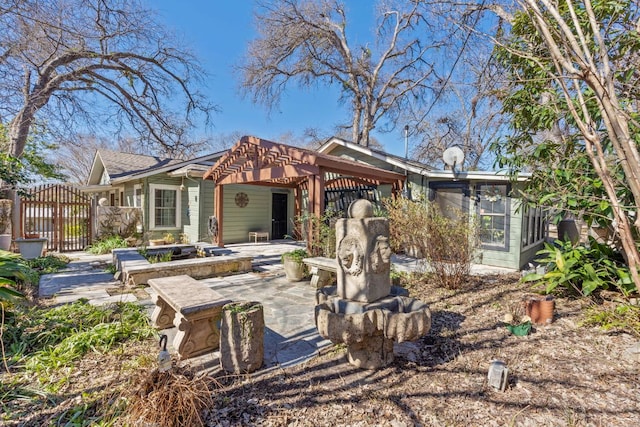 back of property with a gate, a patio area, and fence