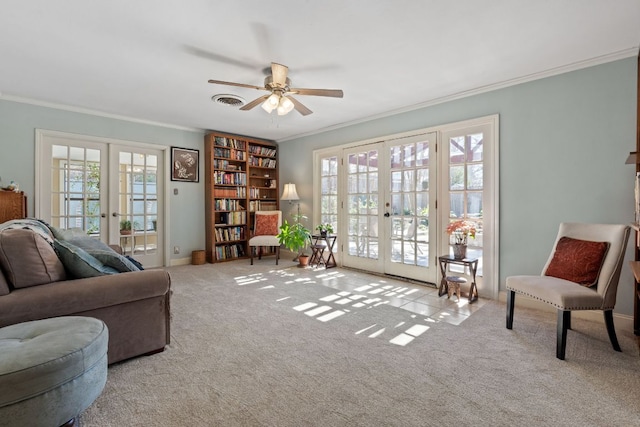 sitting room featuring french doors, visible vents, ornamental molding, carpet flooring, and ceiling fan