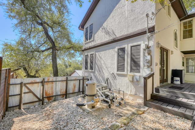 exterior space featuring a gate, fence, and stucco siding