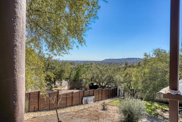 view of yard with fence and a view of trees