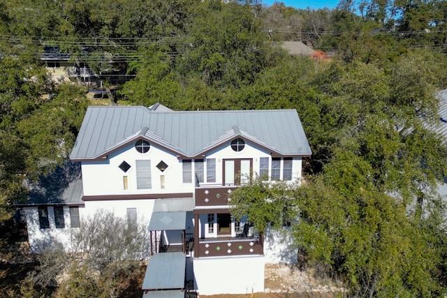 view of front of house with a standing seam roof, metal roof, and stucco siding