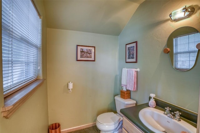 bathroom featuring vaulted ceiling, vanity, toilet, and baseboards