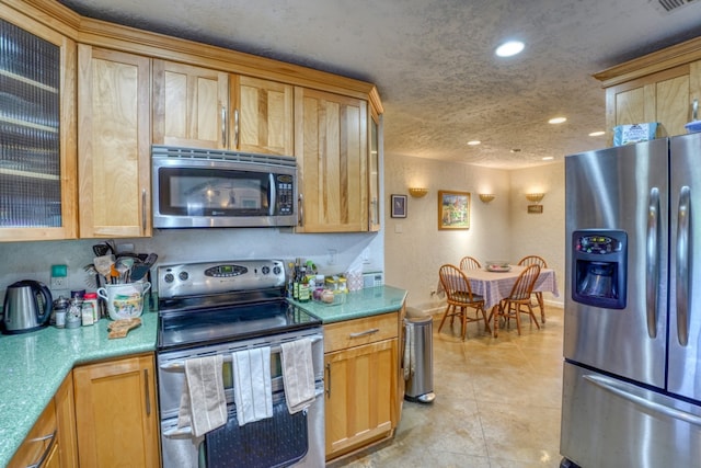 kitchen with light tile patterned floors, stainless steel appliances, recessed lighting, visible vents, and glass insert cabinets