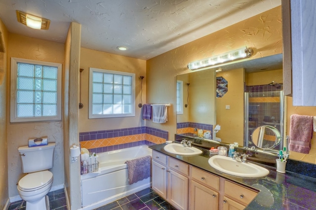 full bathroom with toilet, a garden tub, a sink, and a stall shower