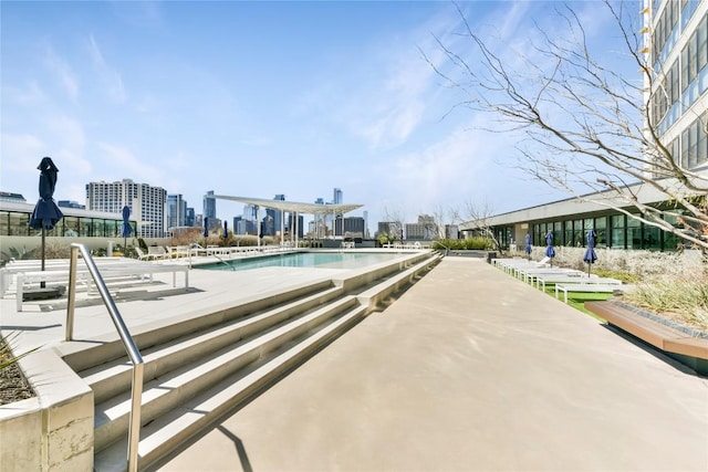 community pool with a patio area and a view of city