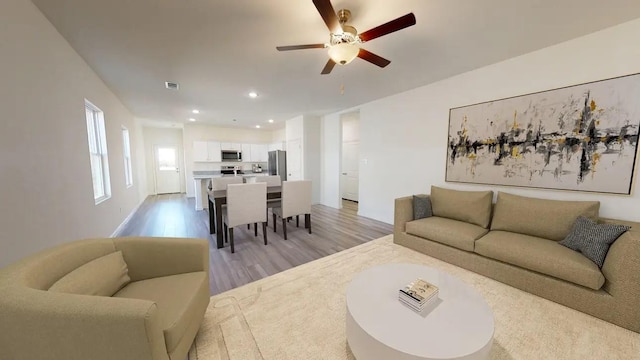 living area with a ceiling fan, recessed lighting, visible vents, and light wood-style flooring