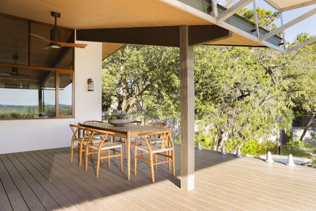 wooden deck with outdoor dining space and a ceiling fan