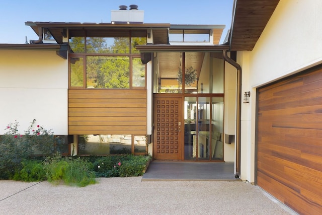 property entrance featuring stucco siding and a chimney