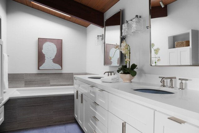 bathroom with beamed ceiling, double vanity, wood ceiling, and a sink