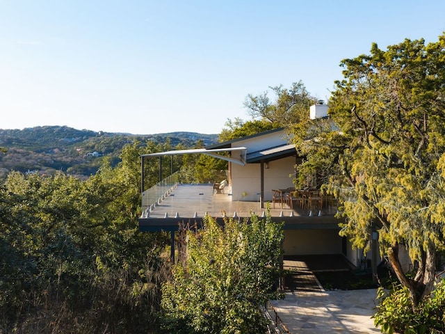view of property exterior featuring stairway, a balcony, and a mountain view